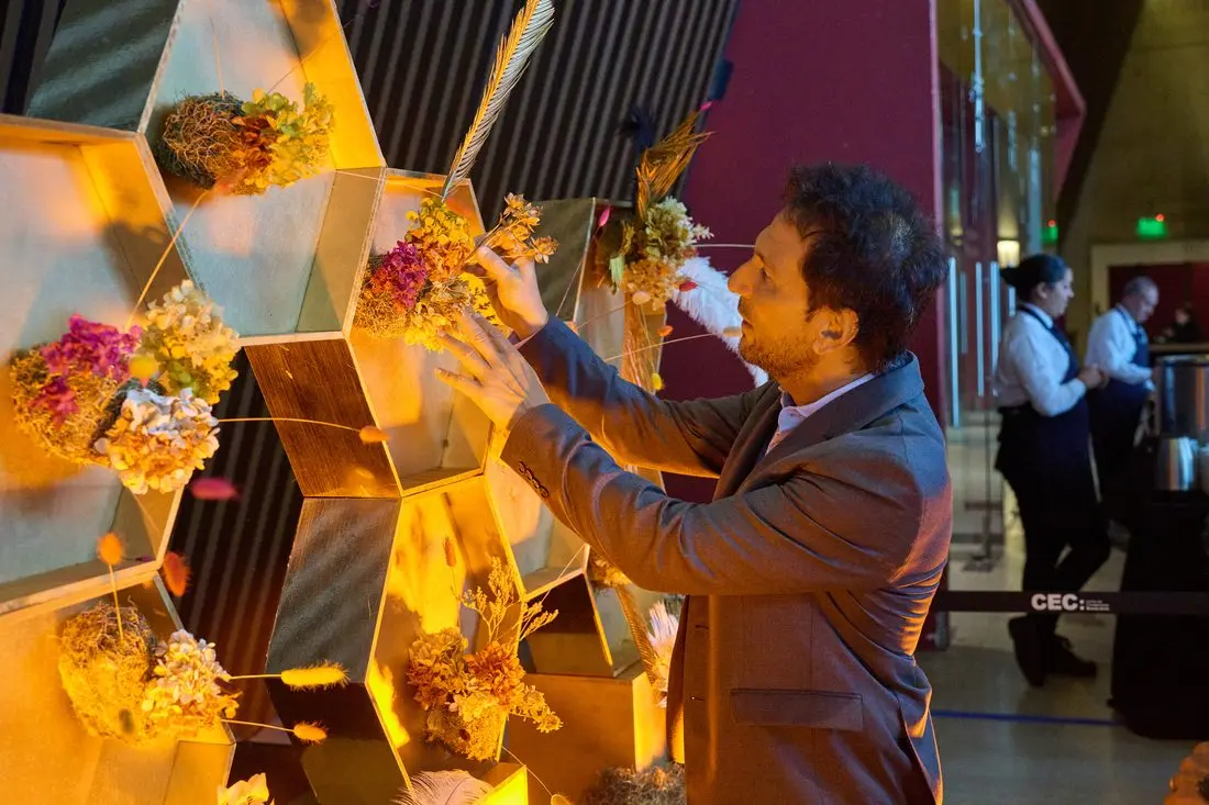 Cada asistente sumó una flor preservada: la obra creció como construcción colectiva.